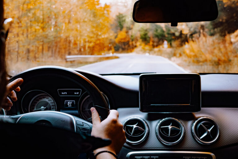 Close up details of driver driving a modern car. Inside of car details, drivers view through windshield